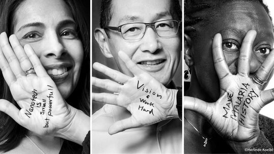 3名のノーベル賞受賞者と自身の研究のエッセンを手のひらに書いた写真